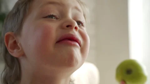 6 year old boy eating green apple pulled out primary tooth Video stock 107935364