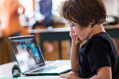6 year old boy having a remote schooling session with his teacher Stock Photos