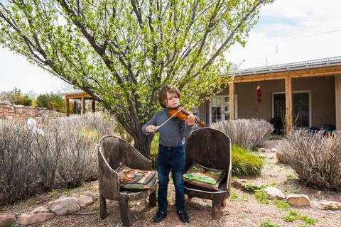 6 year old boy playing violin outside of his home Stock Photos