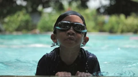 6 years old Asian boy learns to swim by diving across the swimming pool. Stock-Footage 229066855