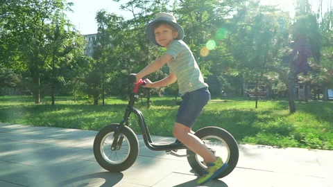 6 years old boy riding a runbike in a park Video stock 134981850