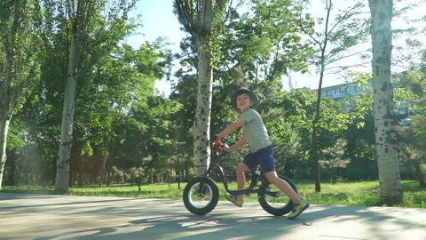 6 years old boy riding a runbike in a park Video stock 134981874
