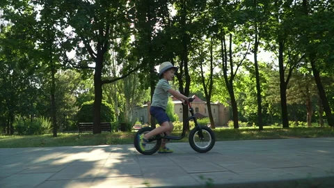 6 years old boy riding a runbike in a park Video stock 134982368