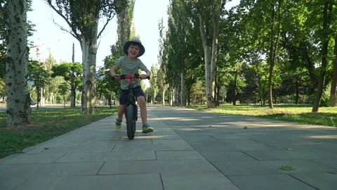6 years old boy riding a runbike in a park Video stock 134982427