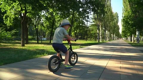 6 years old boy riding a runbike in a park Video stock 134982645