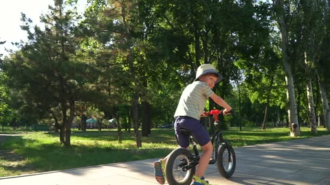 6 years old boy riding a runbike in a park Video stock 134982786