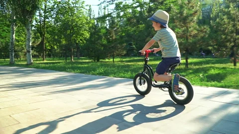 6 years old boy riding a runbike in a park Video stock 134982911