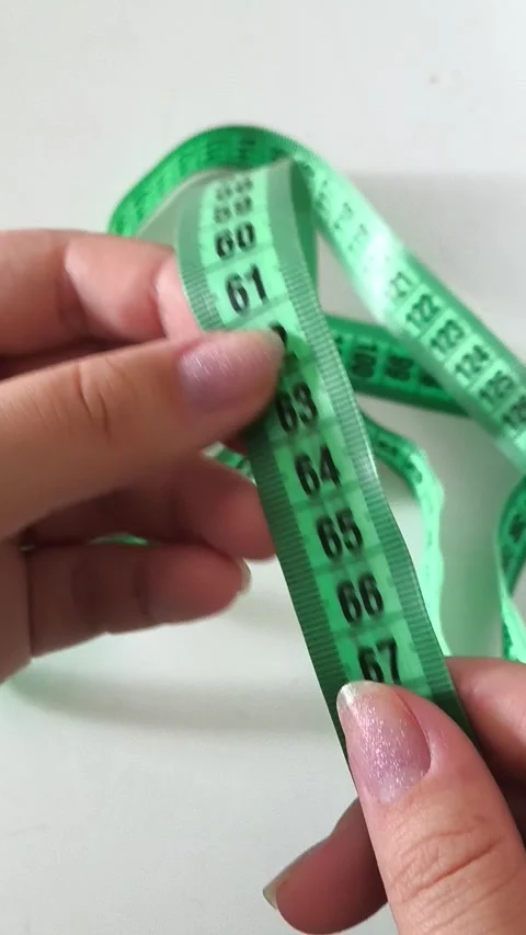 60 centimeters on a centimeter tape. The concept of a thin waist, weight loss. Video stock 313978053