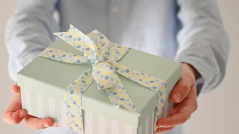 60 fps 4K video of hands of young boy giving present box with blue bow Video stock 164017683