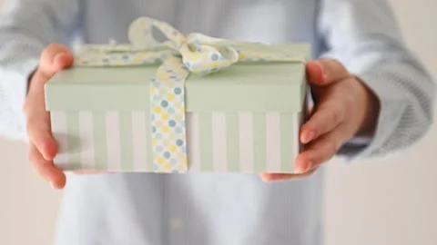 60 fps 4K video of hands of young boy giving present box with blue bow Video stock 164017836
