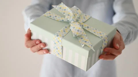 60 fps 4K video of hands of young boy giving present box with blue bow Video stock 164019602