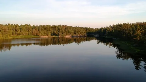 60 FPS: Smooth fly low above calm water and ascending over forest in the end Stock Footage 112229827