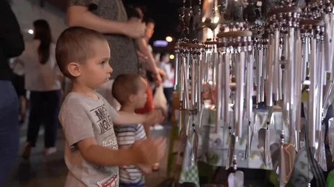 60 FPS: Toddler Playing with Silver Wind Chimes at Thai Street Market Stock-Footage 124210973