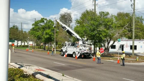 60813Utility Workers Directing Traffic Around Bucket Truck and Roadwork on Subur Stock Footage 330556157