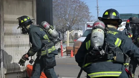 60fps firefighter dragging hose at emergency safety training putting out Stock Footage 156896320