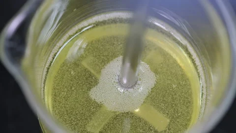 6368 stirr oil in the beaker by using mechnical stirrer Stock Footage 146458033