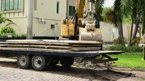 6977Construction Site With Excavator Loading Timber On Flatbed Trailer In Urban Stock Footage 320321716