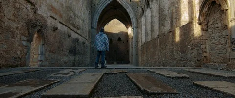 6K - Man Standing Inside an Eerie View Castle in Ireland Stock Footage 123377438