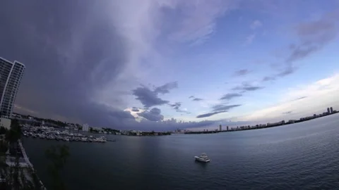 6th floor view of blue sky with gray clouds and a lonely boat in Miami Beach 스톡 동영상 135355321