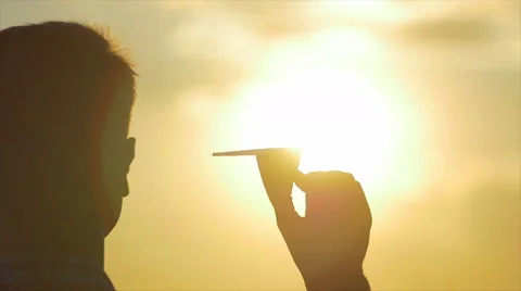 7 in 1 video! Man (pair) hold paper airplane and launch by the bright sun Stock Footage 50550017