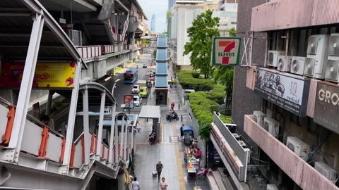 7-11 shop is seen next to a BTS sky train station in Bangkok, Thailand 4K Stock Footage 243719905
