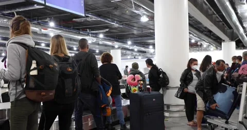 7 7 2022 Crowds of air travelers wait at a baggage reclaim carousel belt at H Stock Footage 212588548