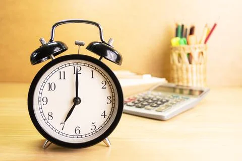 7 AM Clock on work desk in the office Time of business working Stock Photos