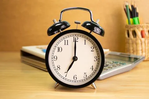 7 AM Clock on work desk in the office Time of business working 스톡 사진
