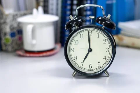 7 AM Clock on work desk in the office Time of businessman working concepts .. Stock Photos