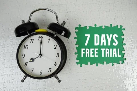 7 Days Free Trial text with alarm clock on green background Stock Photos