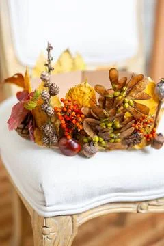  7 October 2023: In autumn elegant crown made of leaves lies on white chai... Stock Photos