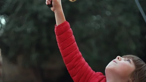7 year old boy enjoys playing with the slingshot outdoors Stock Footage 262346200