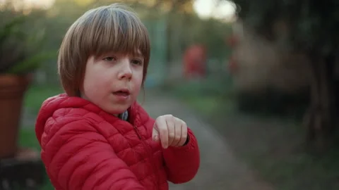 7 year old boy enjoys playing with the slingshot outdoors Stock Footage 262346495