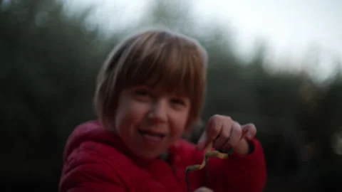 7 year old boy enjoys playing with the slingshot outdoors Stock Footage 262347894