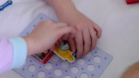 A 7 year old boy plays with a constructor, collects electronic circuits. Close Stock Footage 171570574
