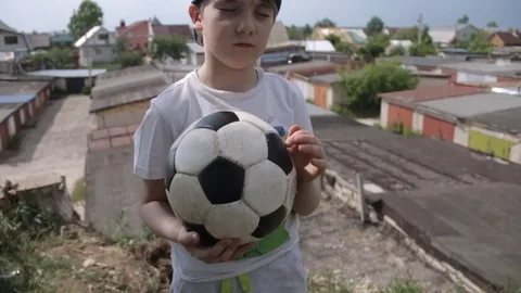 7 year-old Russian white boy in cap with closed eyes and a soccer ball in his Stock Footage 91254530