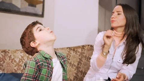 7 years old boy is gargling with herbal decoction, female doctor learning him Stock-Footage 101704533