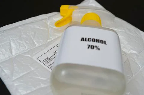 70% Alcohol spray on top of bubble wrap padded envelope with Post label Stock Photos