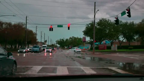70154Rainy Urban Intersection at Dusk With Red Traffic Lights and Reflective Wet Stock Footage 331007607