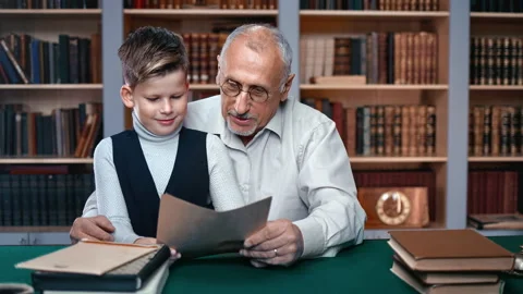 70s grandfather help doing homework little cute male grandkid sitting on vintage Stock Footage 165558443