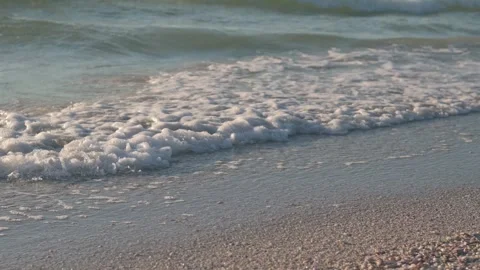 7235Gentle Waves on Sandy Beach With Long Shadows at Sunset. A serene image of o Stock Footage 320322078