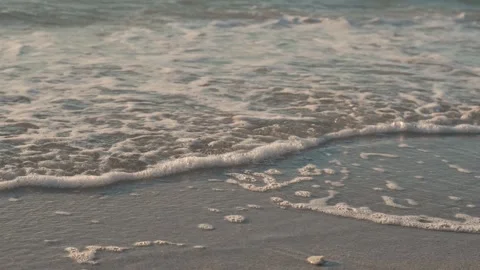 7240Gentle Waves on Sandy Beach With Long Shadows at Sunset. A serene image of o Stock Footage 320322484