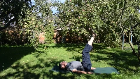A 76-year-old man performs an exercise to strengthen his abdominal muscles in hi Stock Footage 317638714