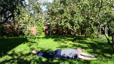 A 76-year-old man performs exercises to strengthen his abdominal and back muscle Stock Footage 336916618