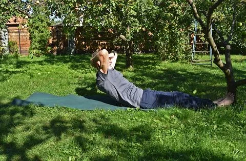 A 76-year-old man performs an exercise to strengthen his abdominal muscles .. Stock-Fotos