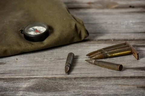 7,92 x 57 - rustic ammos, poncho and old compas lies on the wooden background Stock Photos