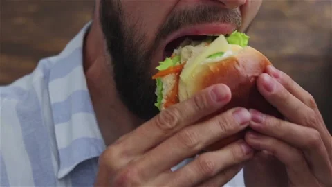 7bearded man  eats healthy chicken burger with  vegetables close up Stock Footage 120496604