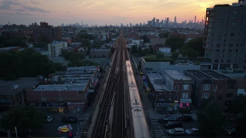 8-15-26, Queens, NY, USA - symmetrical wider sunset aerial shot of train Stock Footage 342305465