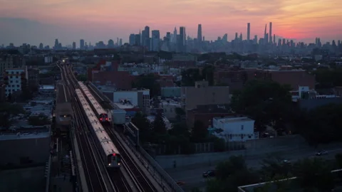8-15-26, Queens, NY, USA - sunset shot of elevated train headed away from NYC Stock Footage 342305727