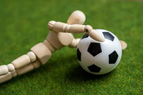 8 February 2023: A wooden figure with a soccer on a playing field. AI Arti... Stock Photos